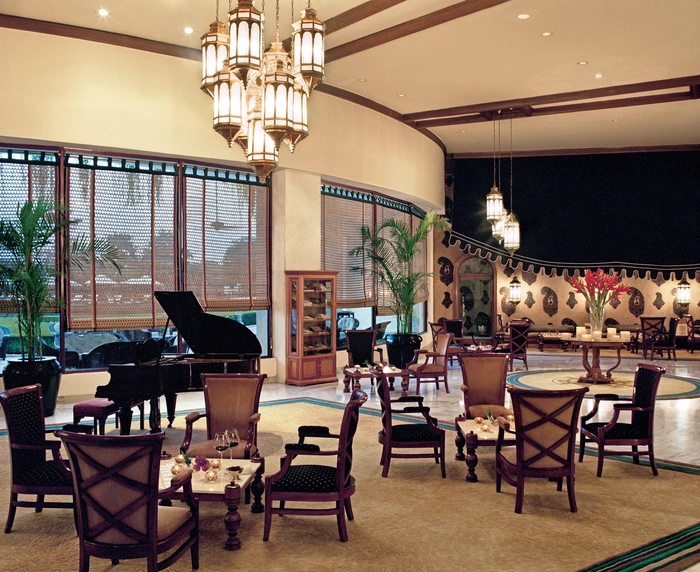 Wooden blinds covering the windows of a lounge of an upscale hotel.