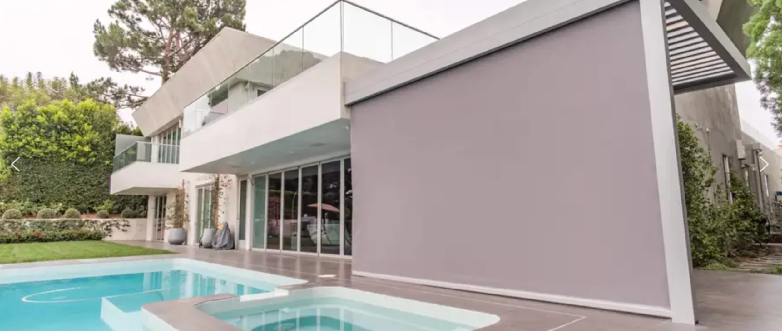 Luxury home with opaque, gray exterior screens installed on the back patio.